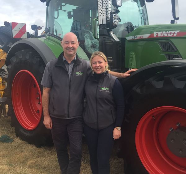 Man and woman in front of tractor