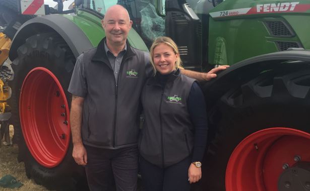 Man and woman in front of tractor