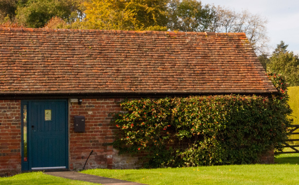 Farmhouse building with blue door and a gate