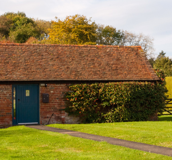 Farmhouse building with blue door and a gate