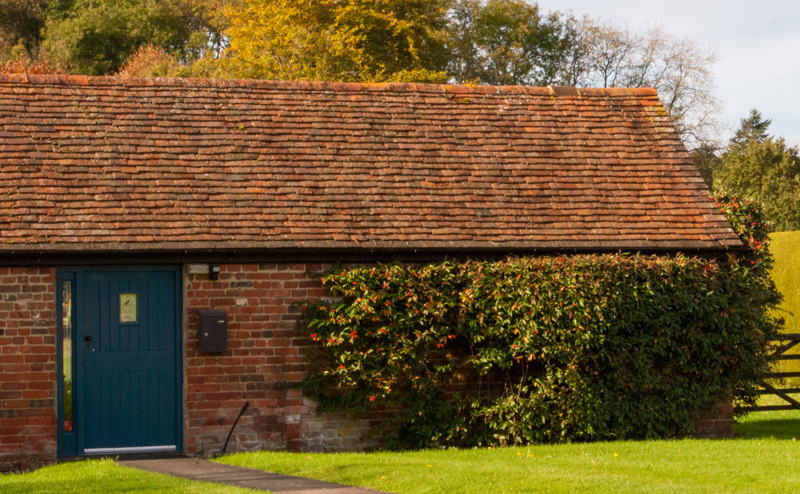 Farmhouse building with blue door and a gate
