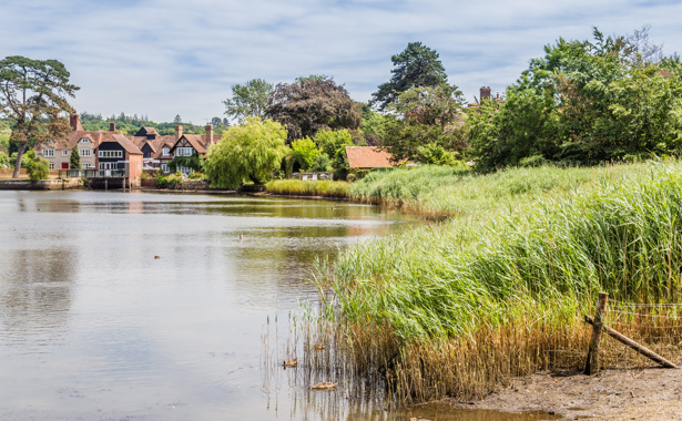 Beaulieu with lake in the foreground and buildings at the back