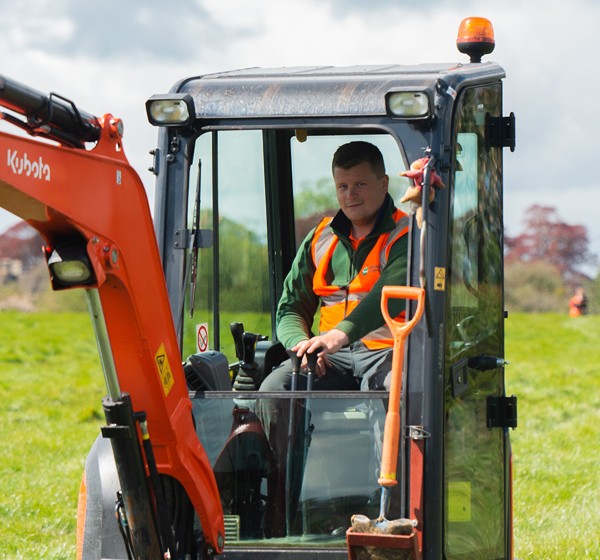 Male employee operating a digger